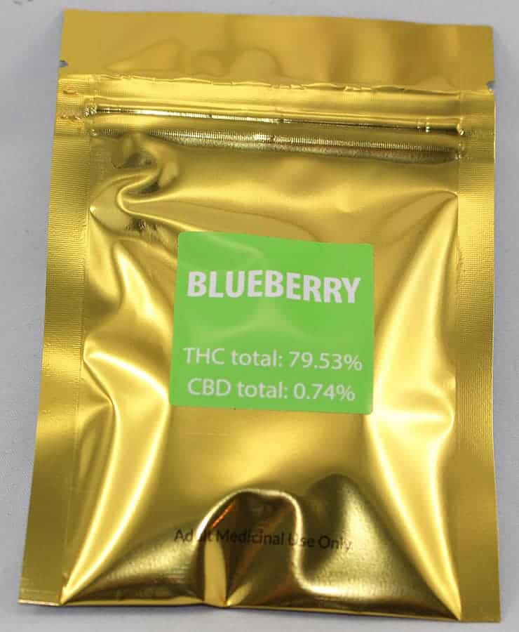 "green gold blueberry kush shatter strain in a metalic gold bag"