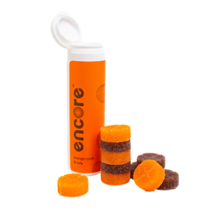 An image of Encore Edibles 600mg Orange Soda and Cola Gummies in their tube packaging with some stacked in front of it to showcase the gummies